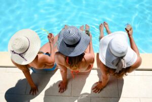 three woman sitting pool side