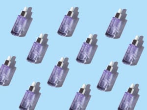 hyaluronic glycolic acid serum anti aging glass bottle on blue pastel background