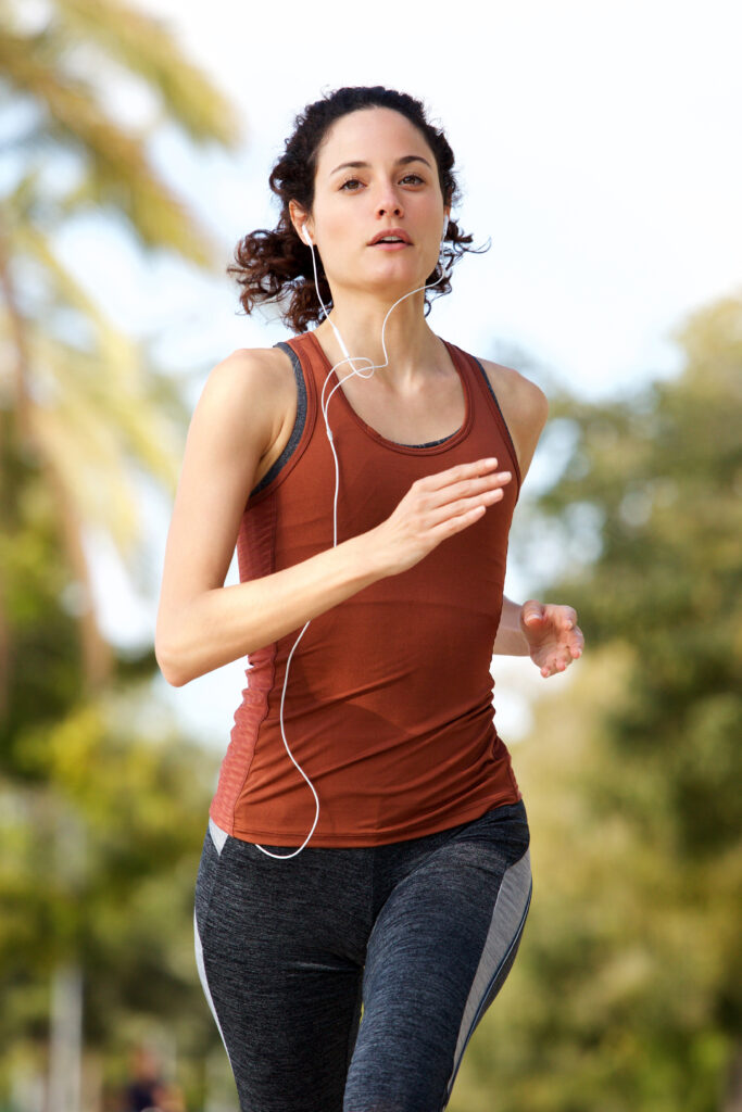 young woman running outside in park