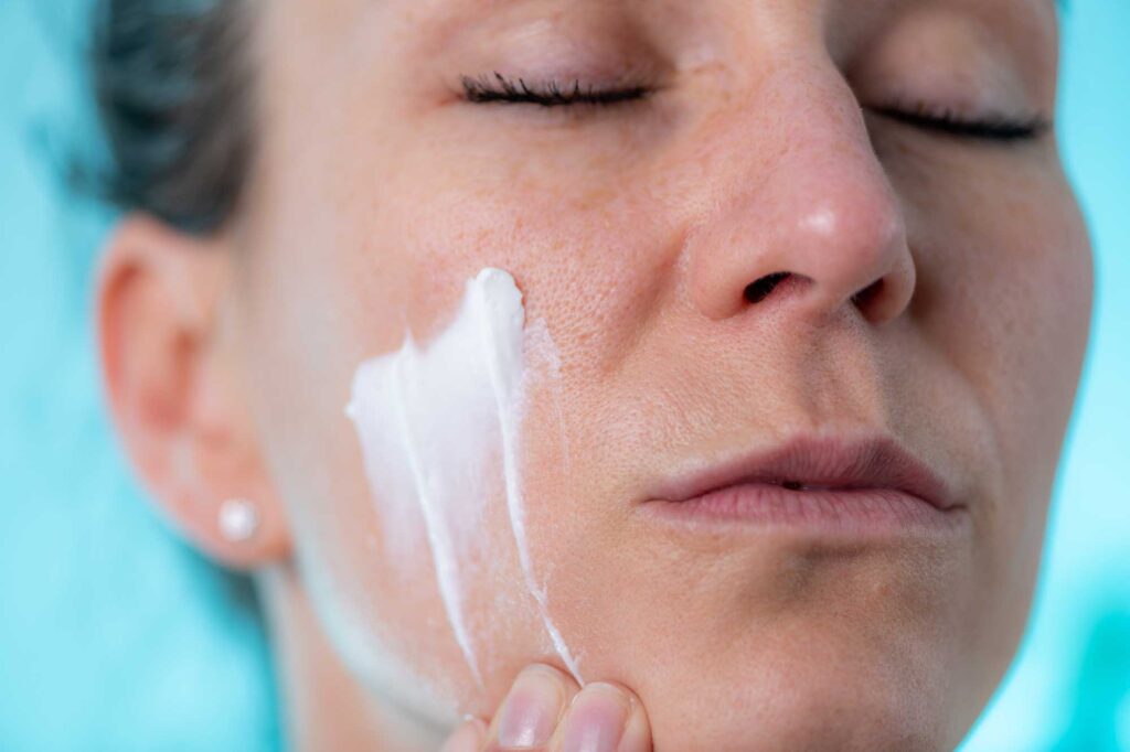 woman applies cream to her face at home 2024 10 18 14 09 00 utc