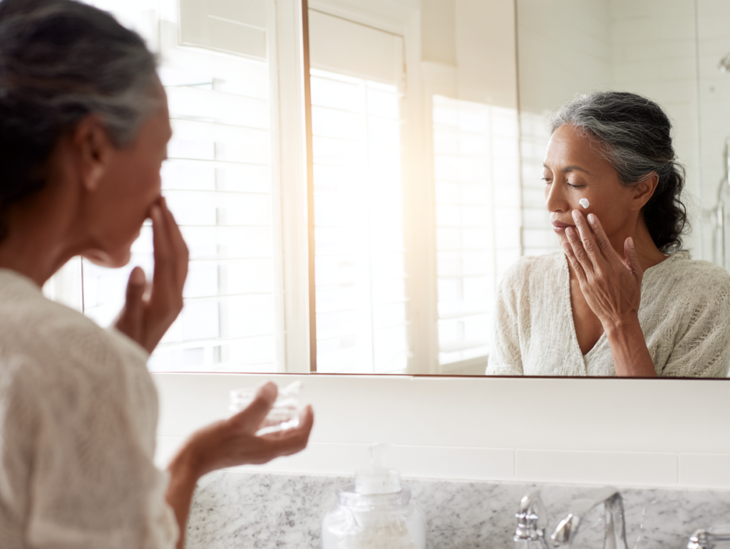 a bright bathroom vanity scene woman 50 applyin 7e81f11f e576 42dc 9a61 4b893b6f3cc8 3