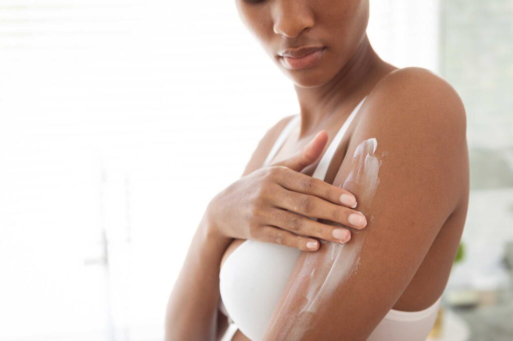 woman applying moisturizer to her arms in bathroom 2025 04 03 01 44 52 utc