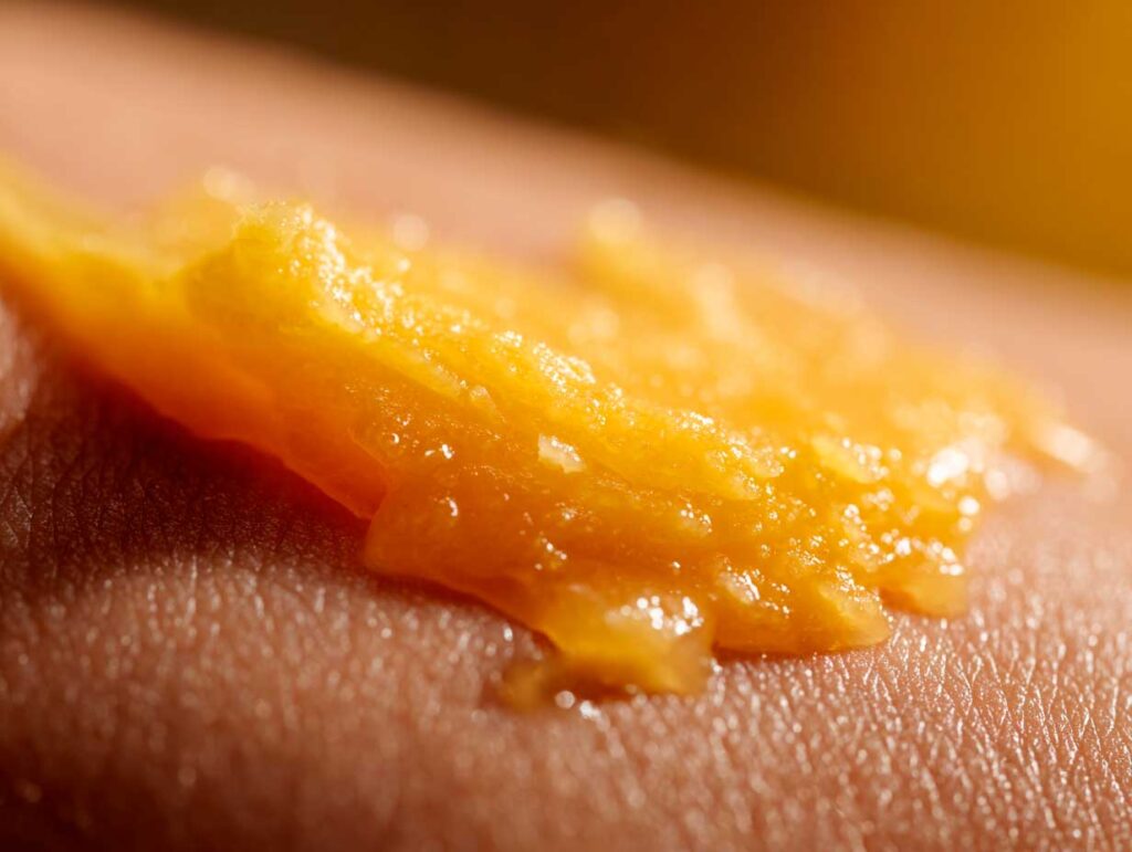 Close-up of orange textured substance on skin.
