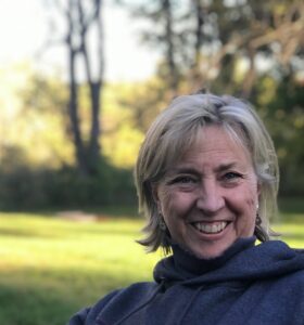 Smiling woman outdoors on a sunny day.