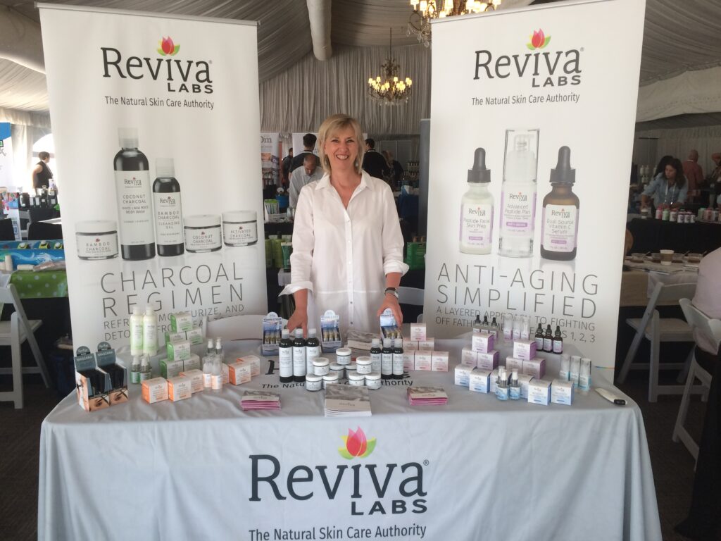 Reviva Labs skincare products display at event.