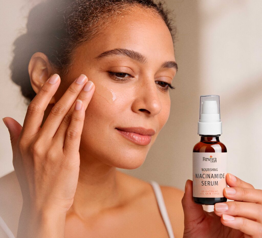 Woman applying niacinamide serum to face