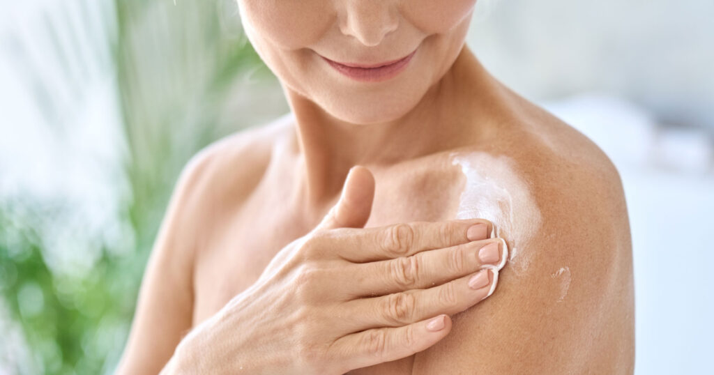 Person applying cream to shoulder