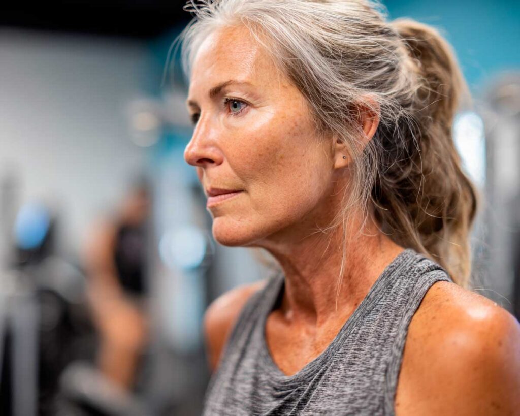 Focused older woman exercising at the gym