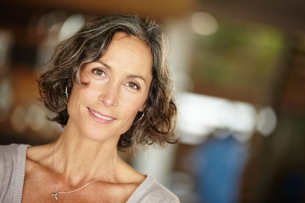 Smiling middle-aged woman with short gray hair indoors