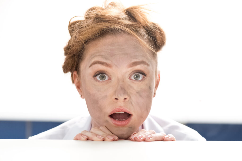 Surprised woman with soot-smudged face and messy hair