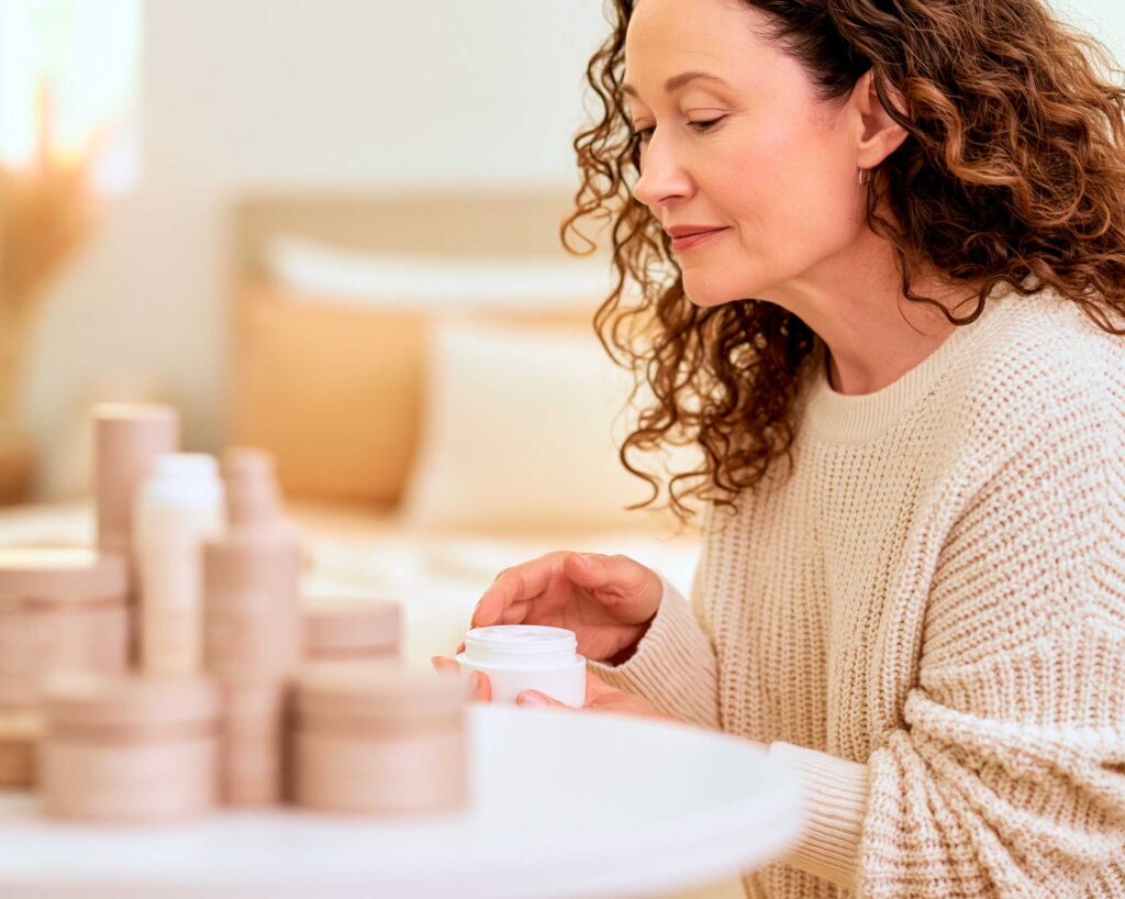 Woman applying face cream at vanity table