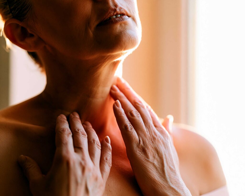 Woman touching her throat in discomfort