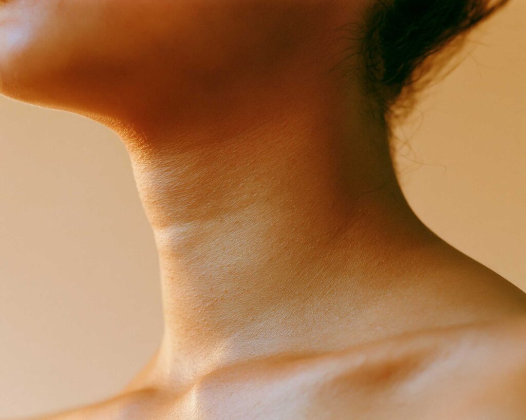 Close-up of person's neck in warm light