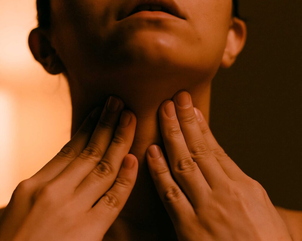 Person touching throat with both hands