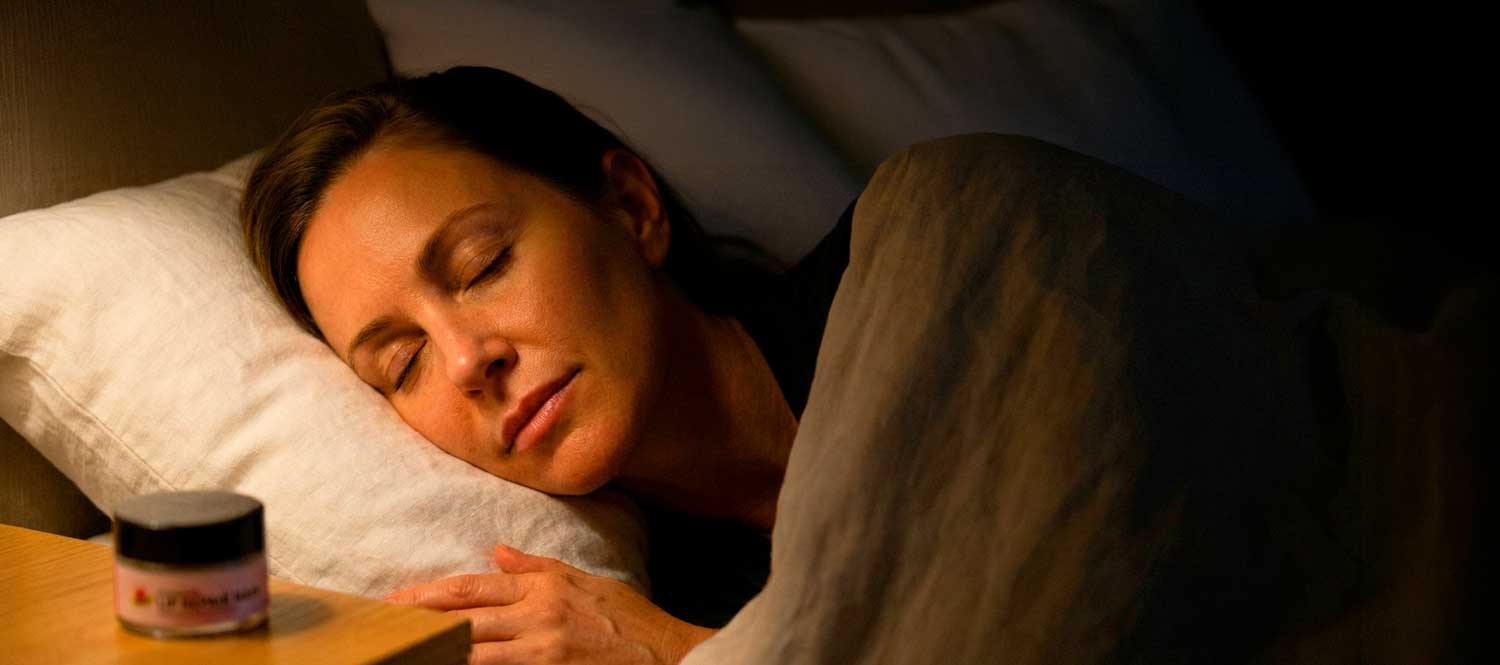 Woman sleeping peacefully beside bedside table at night