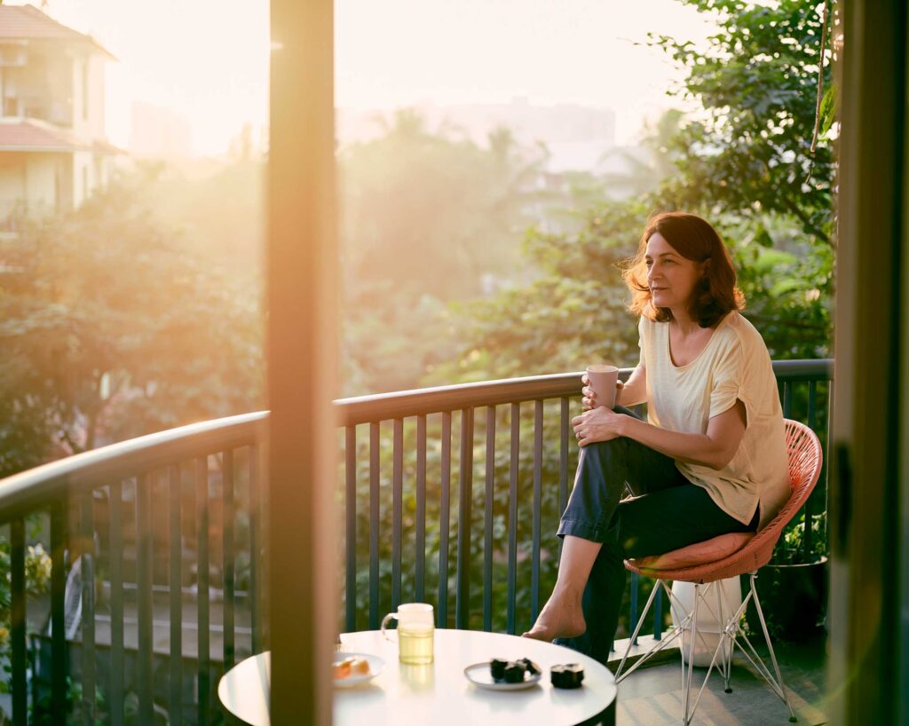 Woman enjoying coffee on sunlit balcony