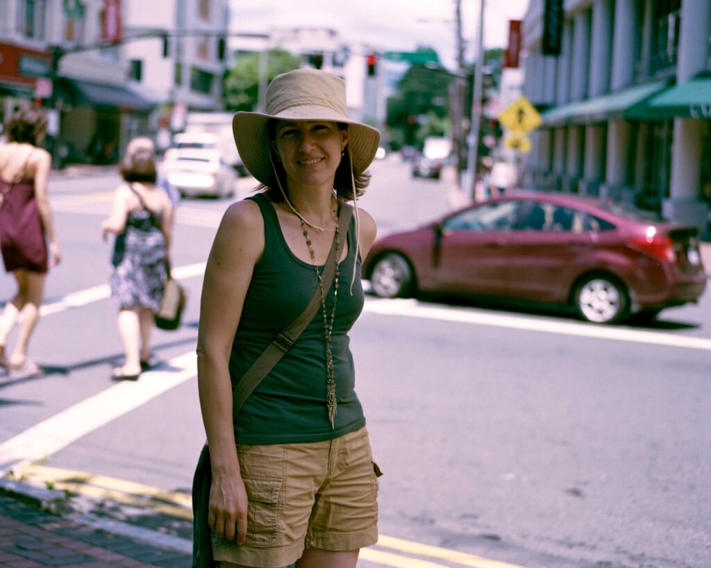 Woman in sunhat smiling on city street