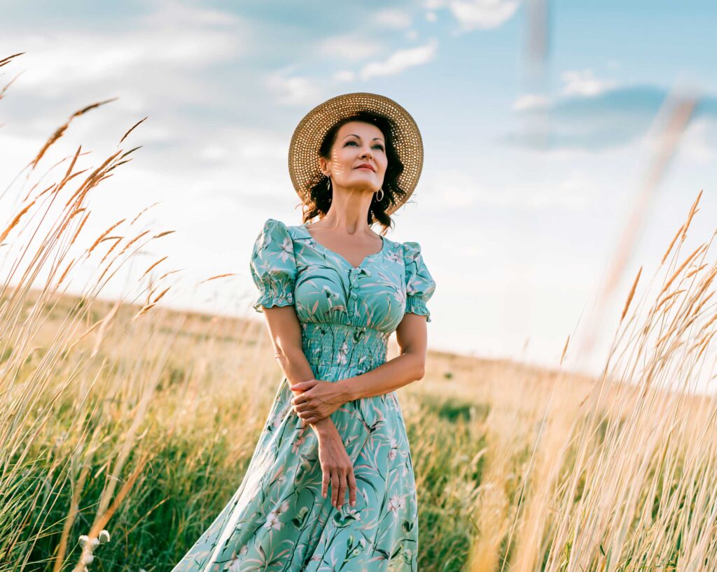 Woman in straw hat standing in golden field