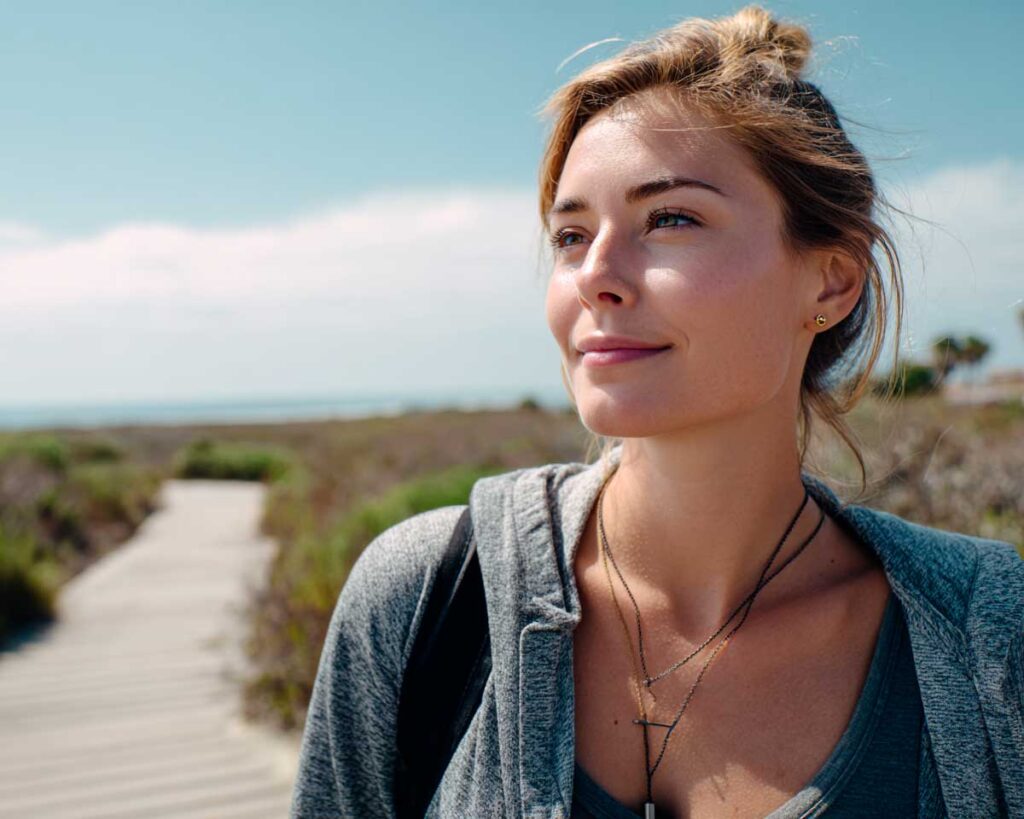 Woman on beach boardwalk looking into distance