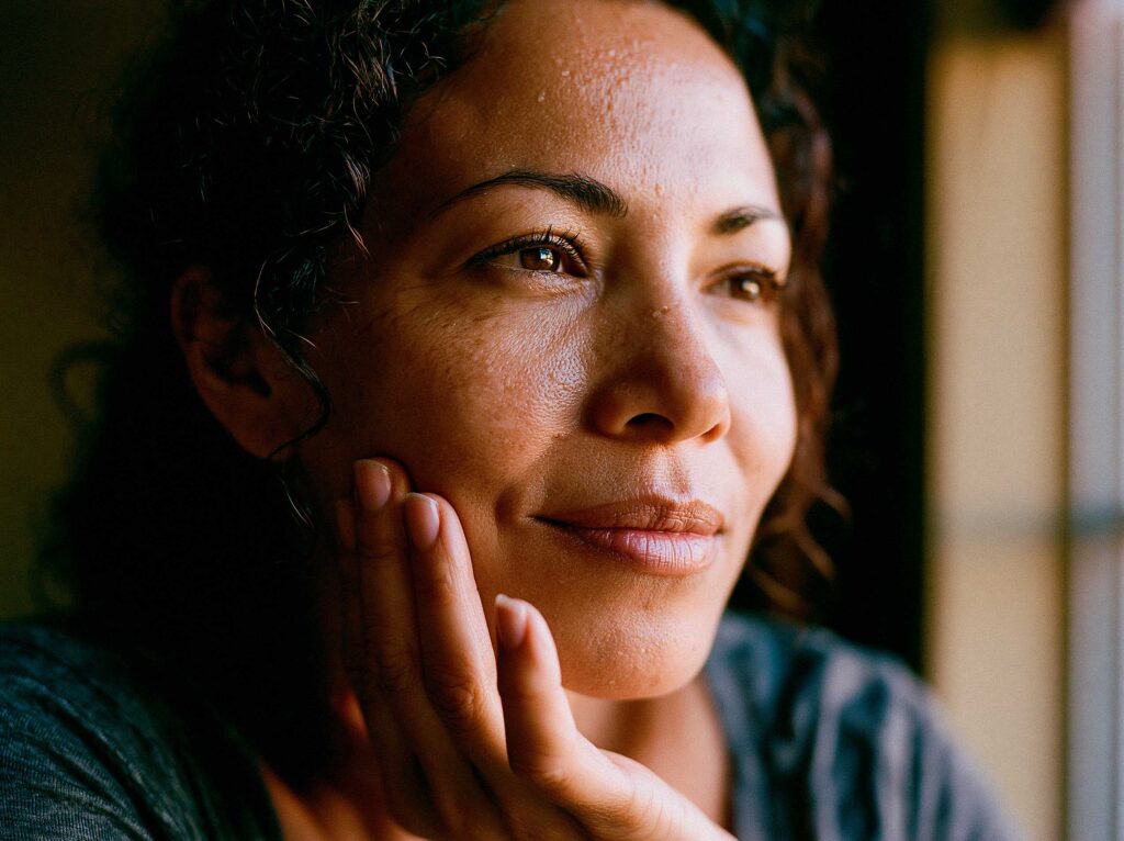 Close-up of woman gazing thoughtfully by window