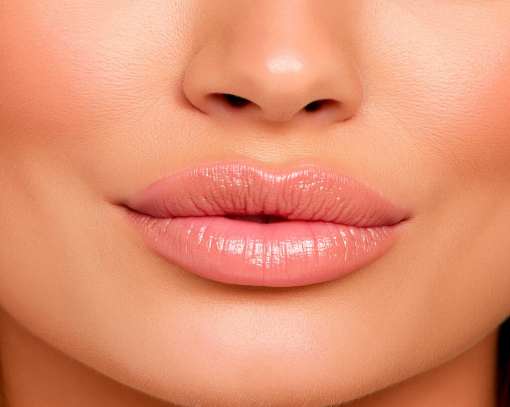 Close-up of glossy pink lips and nose
