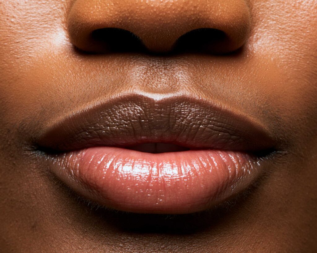 Close-up of nose and glossy lips, dark skin