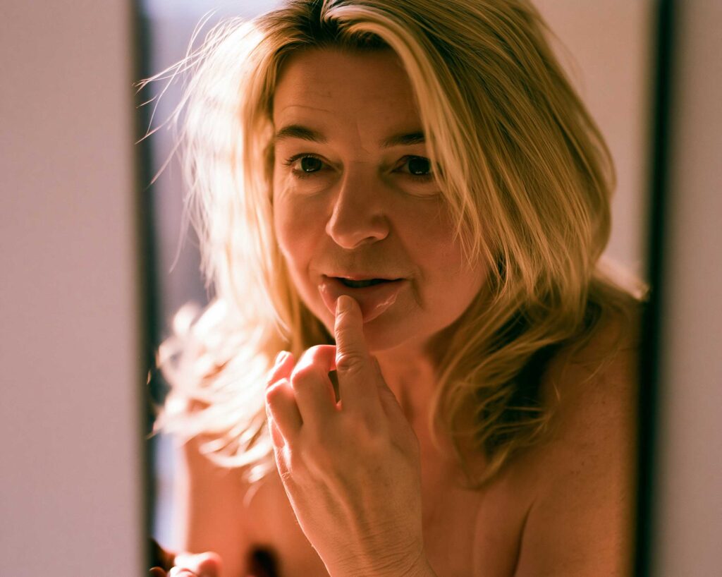 Woman applying lip balm in warm sunlight
