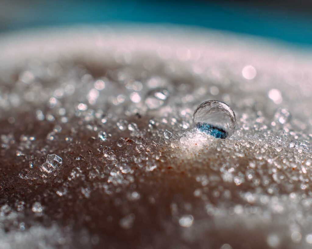 Macro water droplet on sparkling beach sand