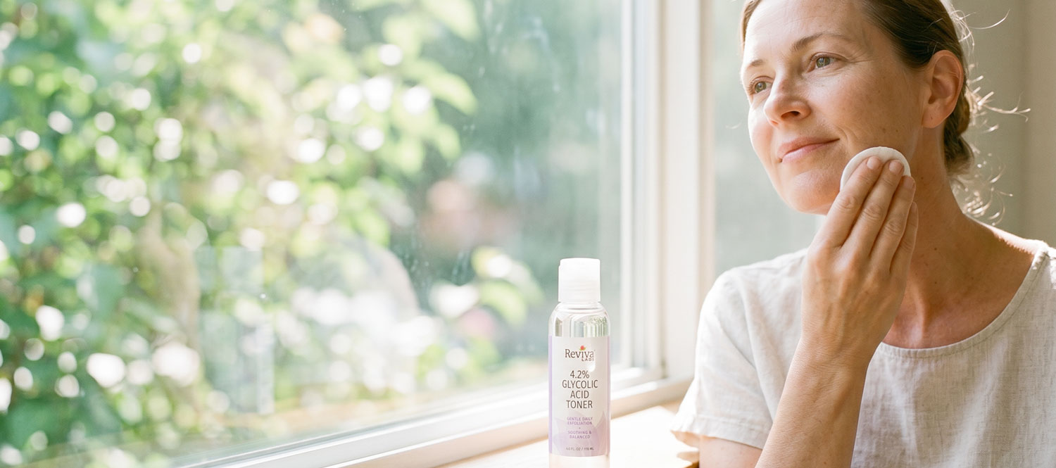 Woman applying facial toner by sunlit window