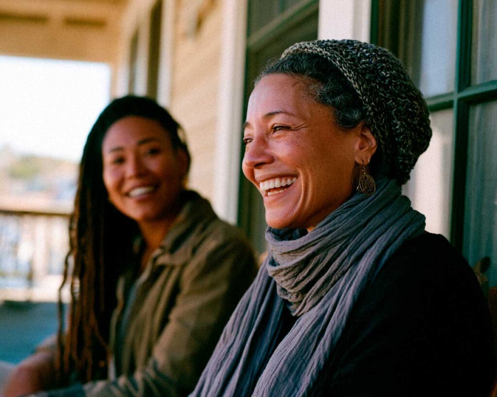 Two women smiling together on a porch