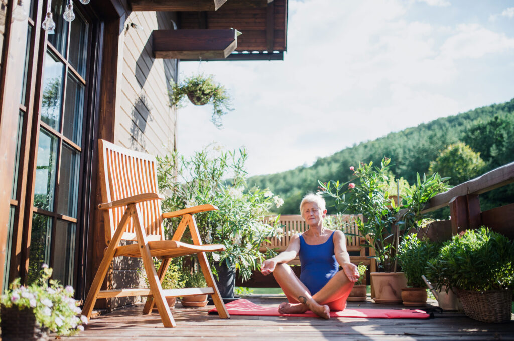 a senior woman sitting outdoors on a terrace in su 2026 03 10 02 10 26 utc