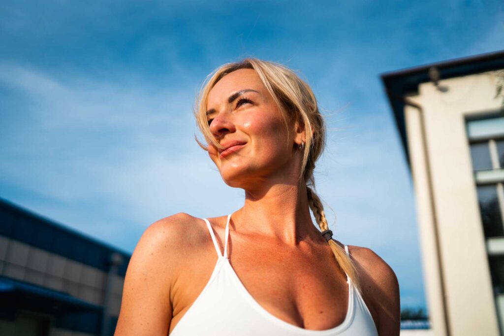 Woman in white top under blue sky