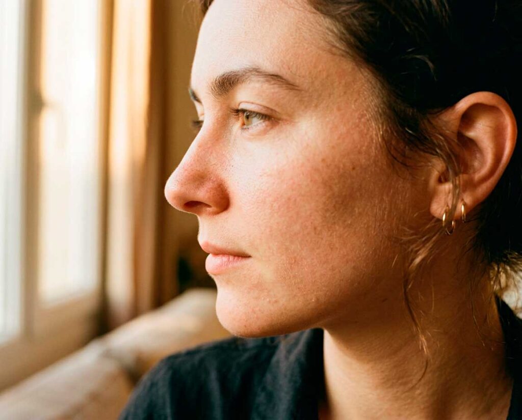 Woman gazing out window in soft light