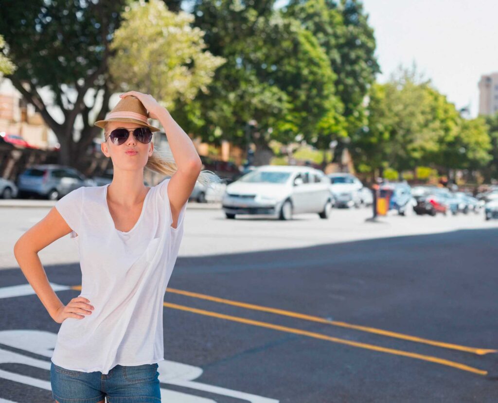 Woman in hat and sunglasses on city street