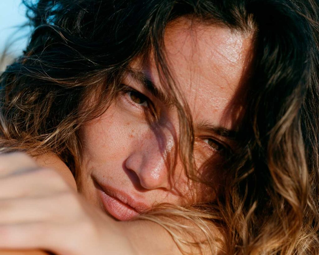 Close-up portrait of woman in warm sunlight