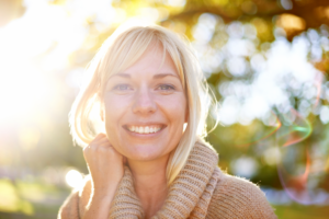 Smiling blonde woman in sunlight outdoors