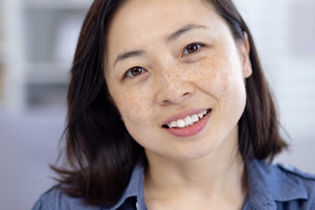 Close-up portrait of smiling woman with freckles