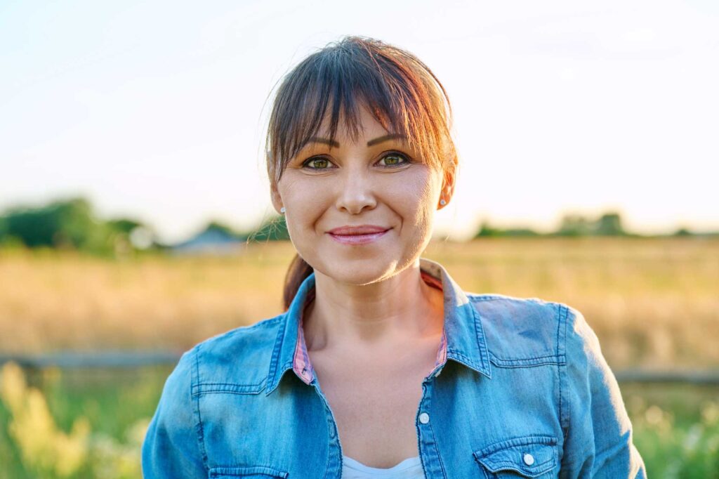Woman smiling in sunlit rural field