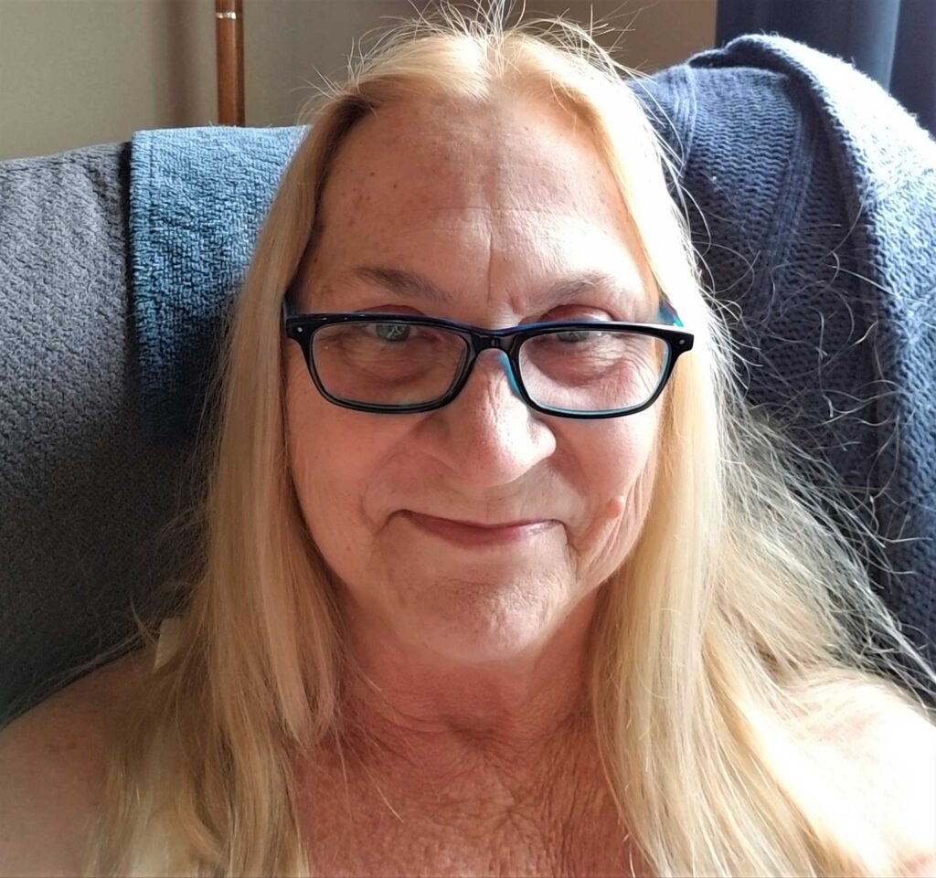 Smiling woman with glasses sitting on couch