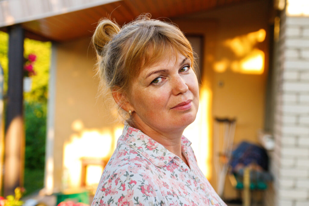 woman in floral shirt smiling outdoors in suburbs 2026 03 23 23 38 35 utc