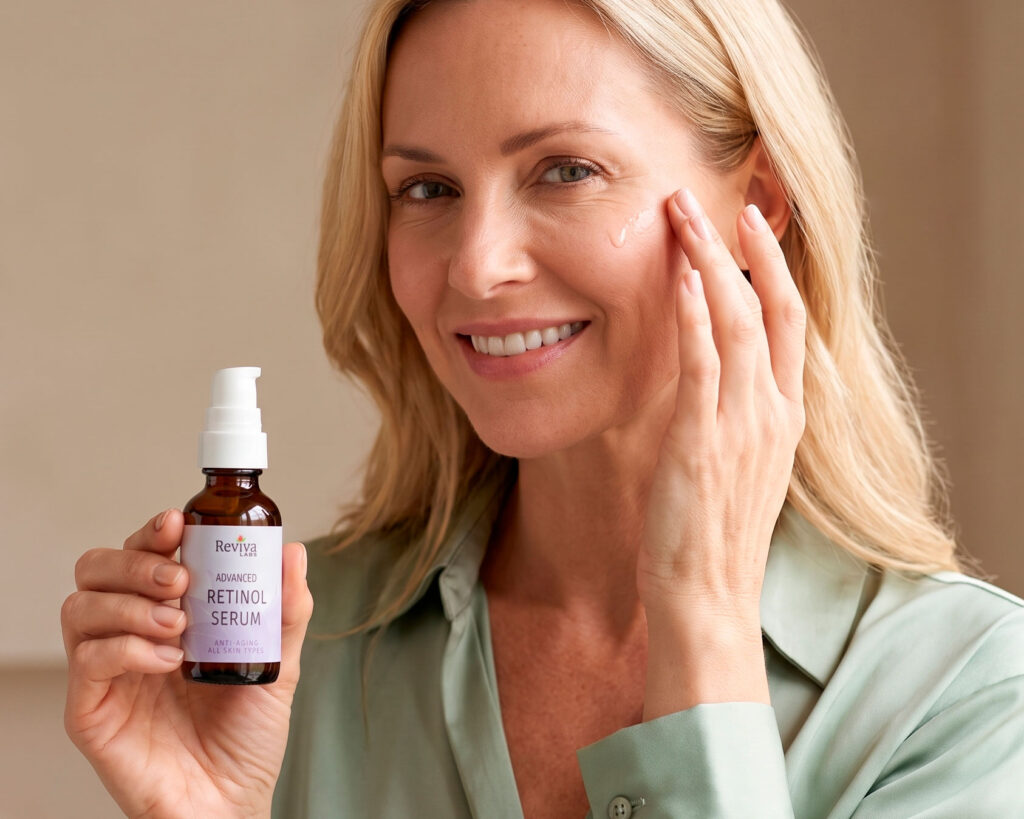 Woman applying retinol serum while holding Reviva Labs bottle