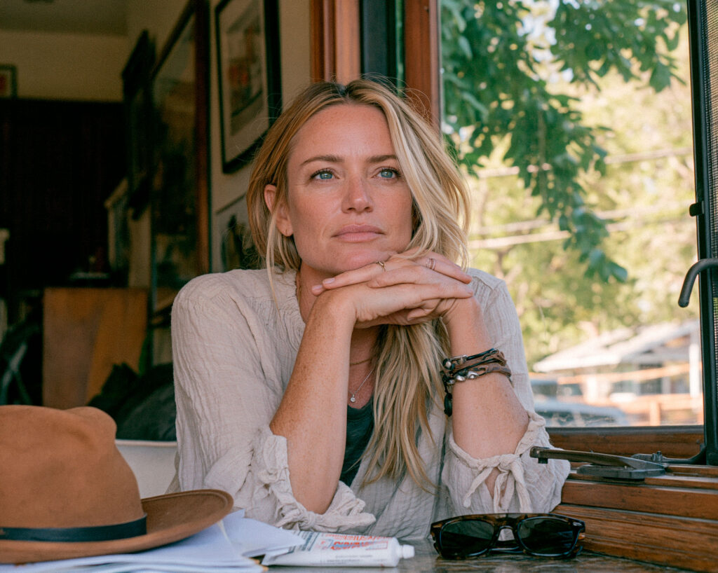 Woman gazing thoughtfully by sunlit window indoors