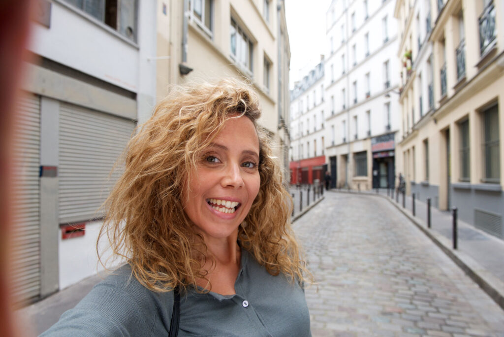 Woman taking selfie on cobblestone city street