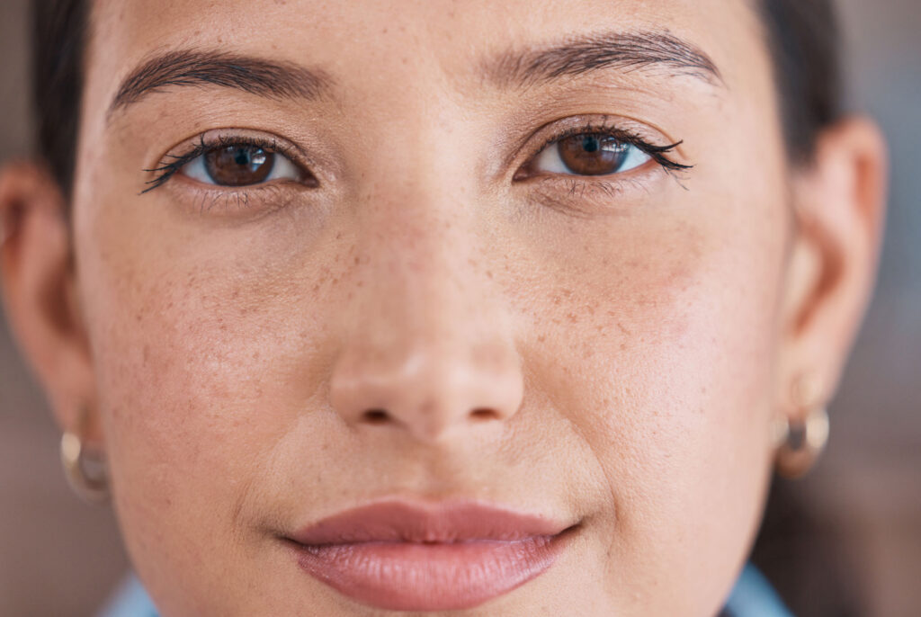 Close-up portrait of woman with freckles and brown eyes