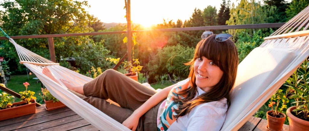 Woman relaxing in hammock at sunset on deck