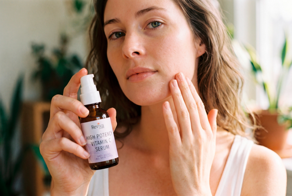 Woman applying vitamin C serum while holding bottle