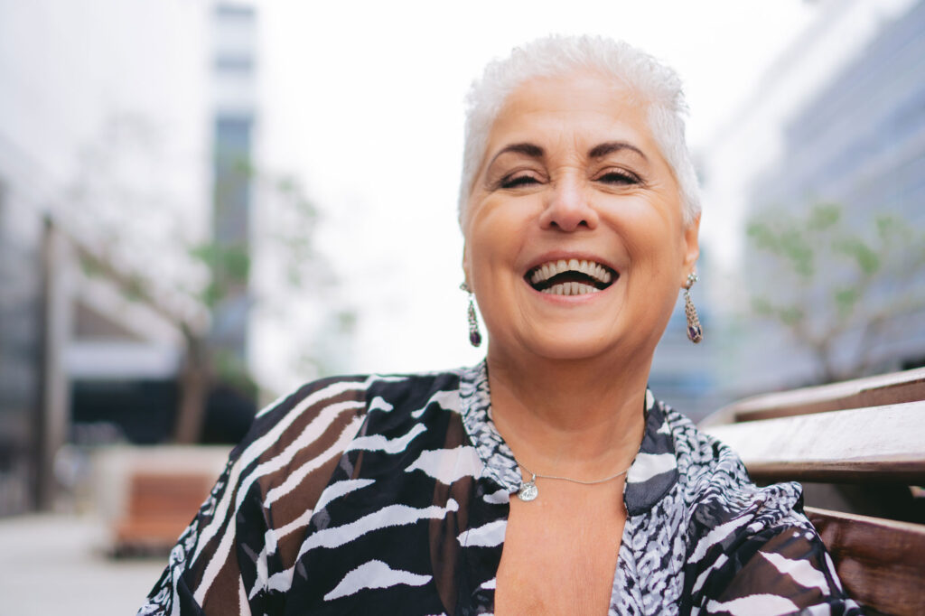 Smiling older woman sitting on outdoor bench