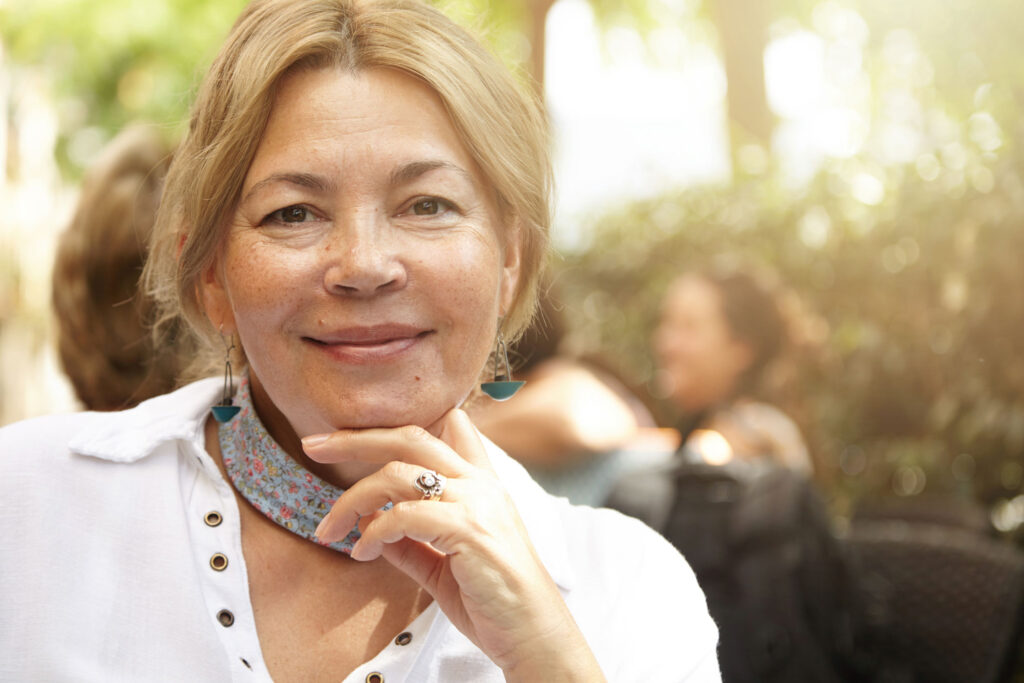 Smiling middle-aged woman outdoors in soft sunlight