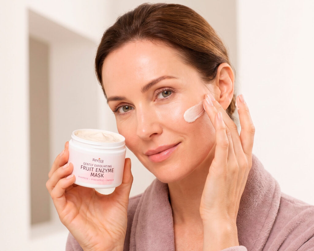 Woman applies fruit enzyme mask while holding skincare jar.