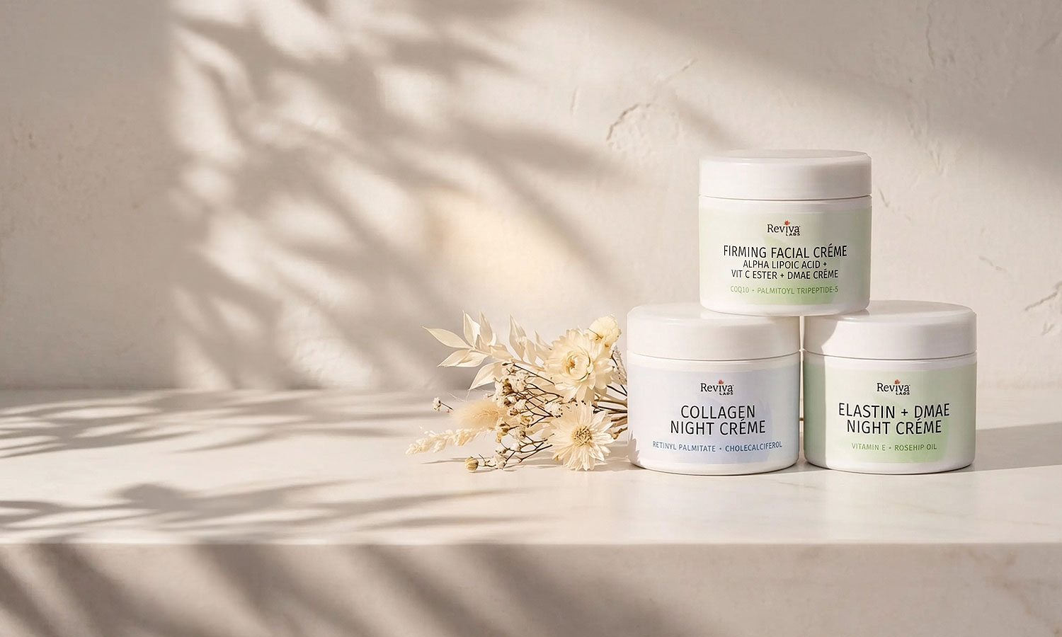 Three Reviva Labs facial cream jars on marble shelf